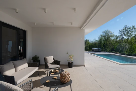 Aménagement paysager extérieur résidentiel avec escaliers en pierre naturelle multicolore, terrasse surélevée en dalles beiges et marches intermédiaires